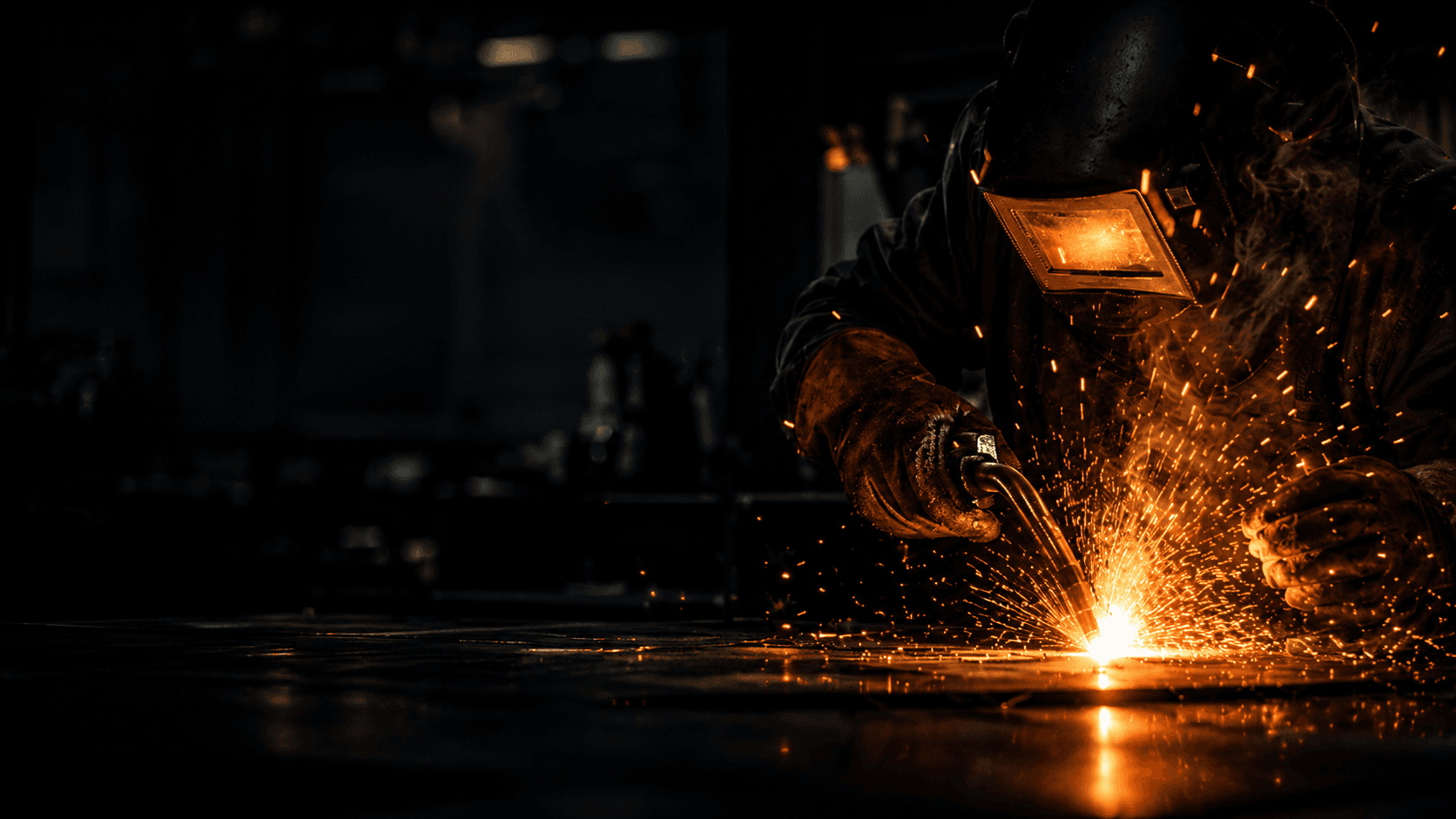 Certified welder at work with sparks flying